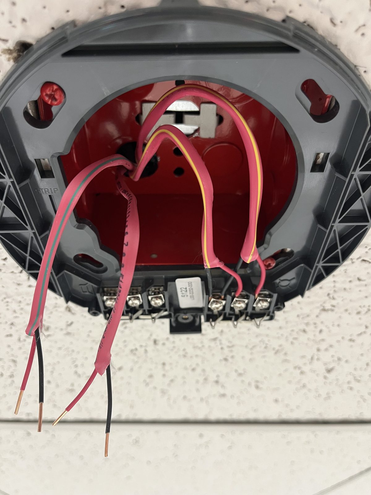 Close-up of a smoke detector base with SLC wiring terminated at the terminal block